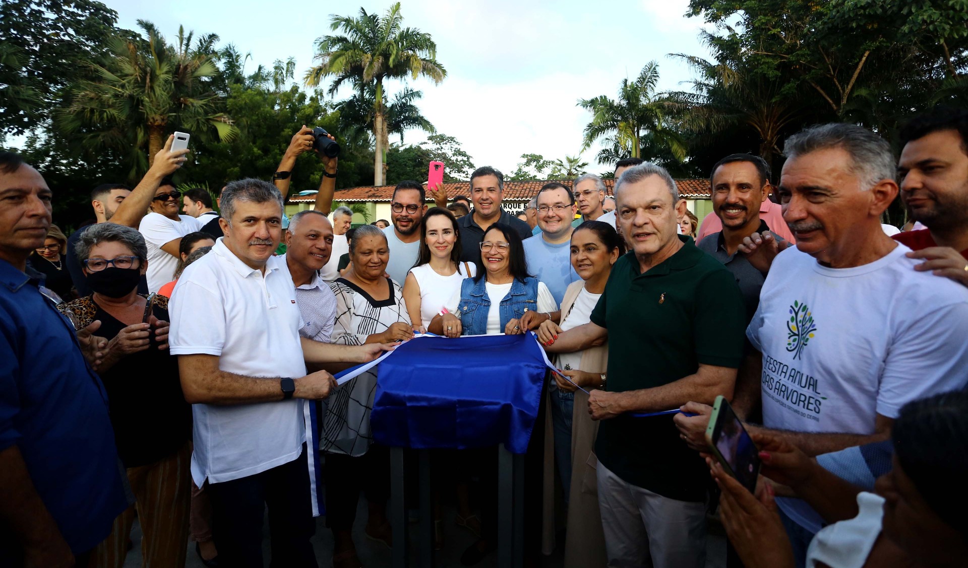 grupo de pessoas posa para a foto na frente da placa de sinalização do parque passaré